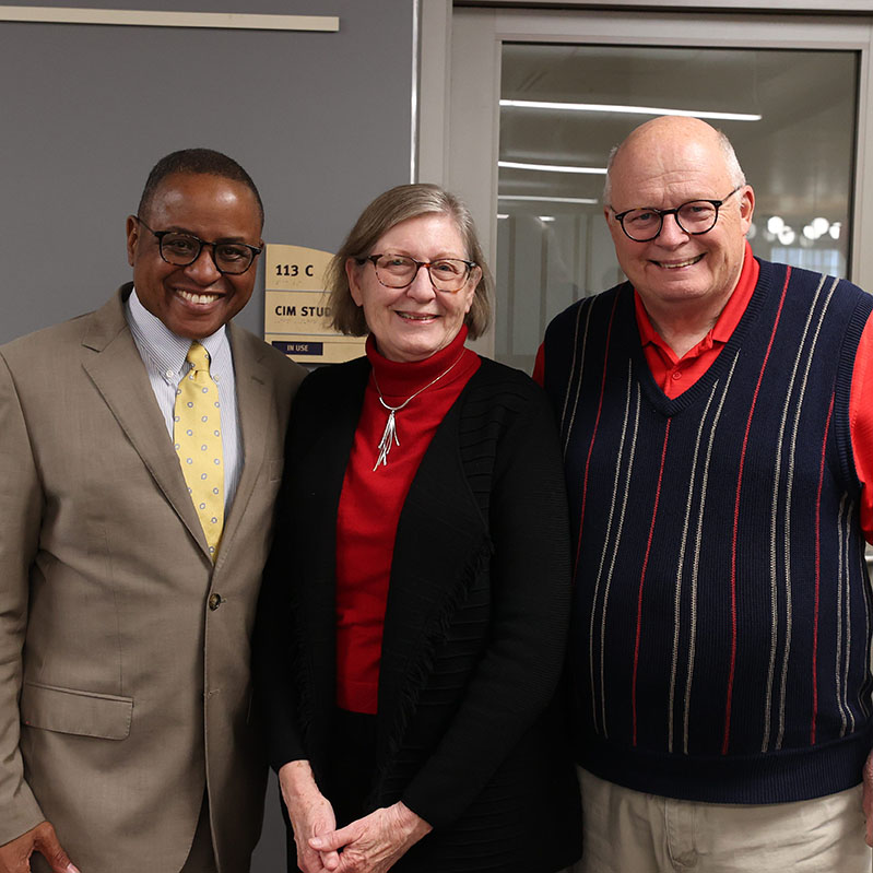 All Ribbon Cutting participants stand in a line holding the red ribbon. Dean Conley - in the middle of the line - holds red scissors and prepares to cut the ribbon. 